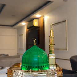 ساعة أذان رقمية بتصميم مستوحى من المسجد النبوي الشريف، تتميز بقبة خضراء مضاءة ومئذنة ذهبية مع شاشة عرض رقمية لمواقيت الصلاة والتاريخ
