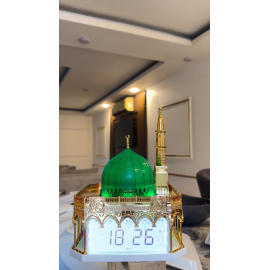 ساعة أذان رقمية بتصميم مستوحى من المسجد النبوي الشريف، تتميز بقبة خضراء مضاءة ومئذنة ذهبية مع شاشة عرض رقمية لمواقيت الصلاة والتاريخ